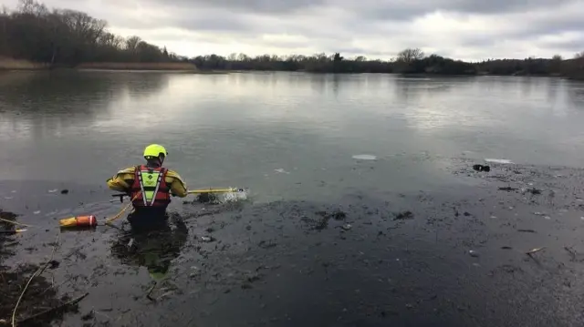 Firefighter wading our to duck