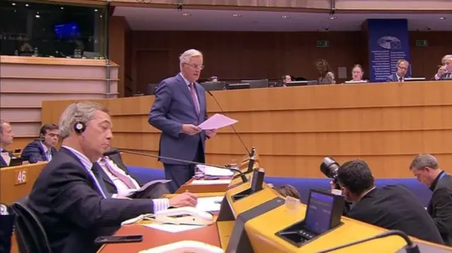 Michel Barnier speaks in the European Parliament, as MEP Nigel Farage takes notes