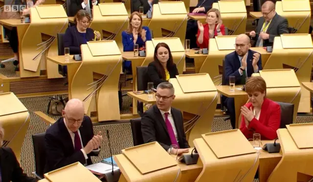 SNP colleagues congratulate Derek Mackay after the general principles of the Budget Bill are agreed