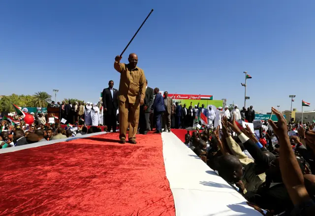 Sudan"s President Omar al-Bashir waves to his supporters during a rally at the Green Square in Khartoum