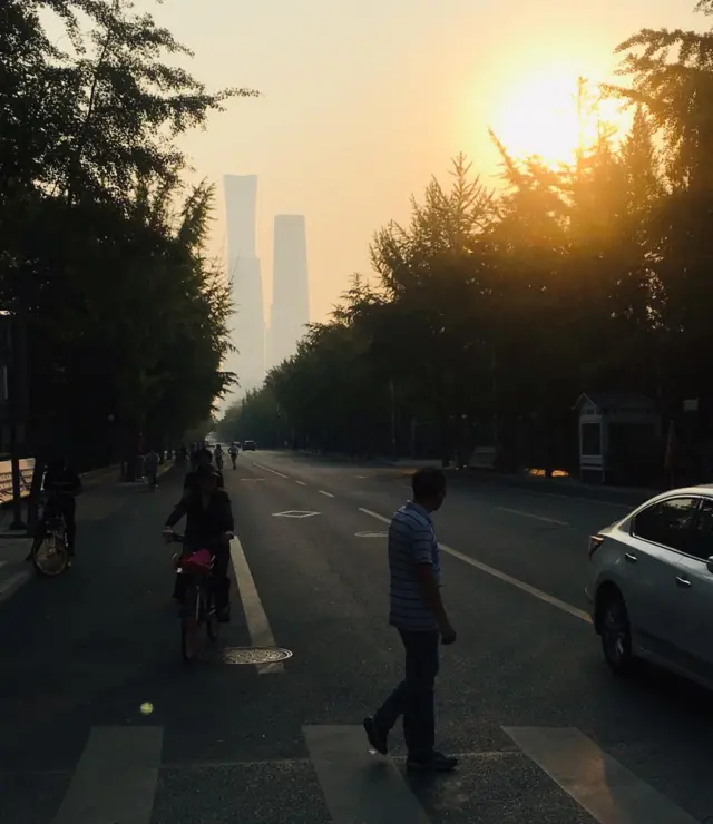 Pedestrians on a quiet street in Beijing at sunrise