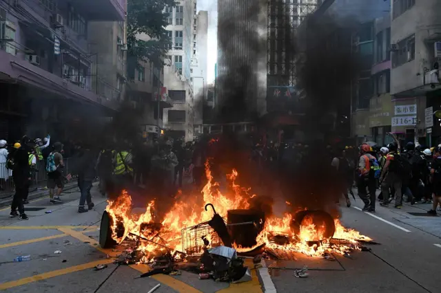 Protesters set fire to debris in the street