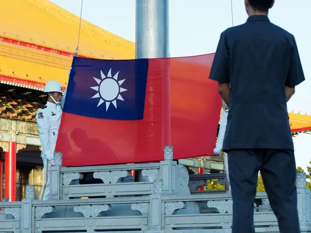 Solider lowers a Taiwanese flag