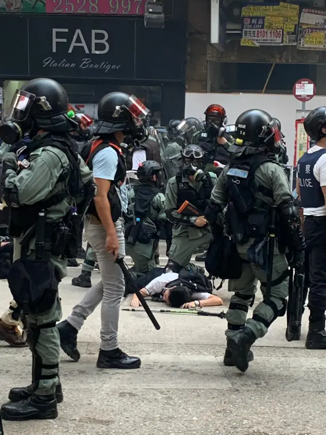 Police officers tackle a man to the ground