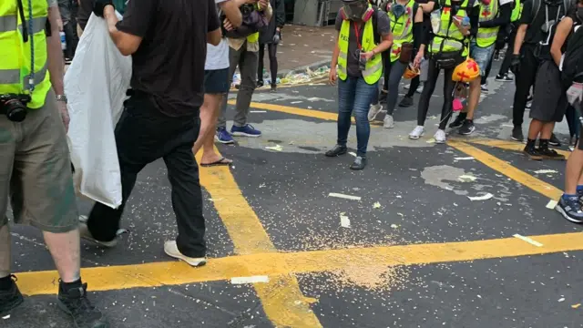 Protesters look at a pile of beans left on the streets