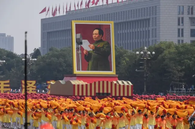 A large portrait of Mao is carried through Tiananmen Square