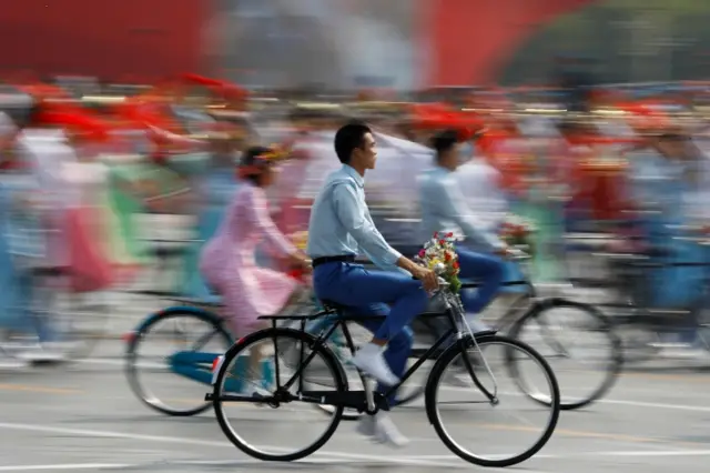 Performers ride bicycles during a parade marking the 70th founding anniversary of People"s Republic of China