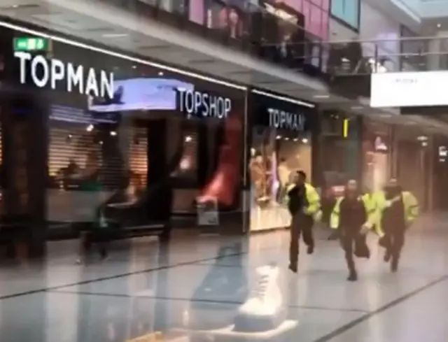 Police running through the Arndale Centre