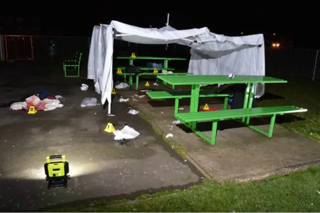 A light illuminates a white sheet, forensic cones and blood stained objects in the play ground area in the park where Jodie Chesney was stabbed