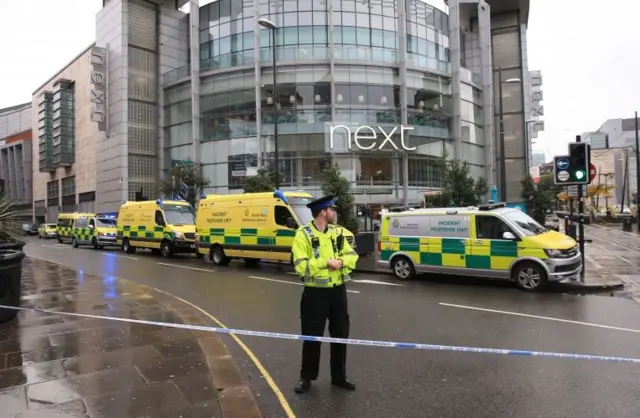 A police officer and ambulances outside the Arndale Centre in Manchester