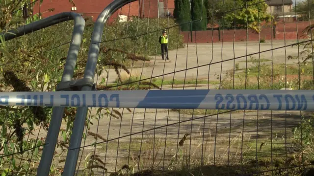 Police tape and an officer