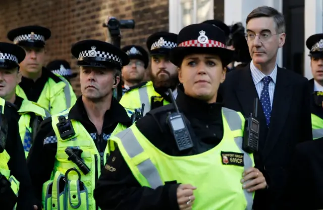 Jacob Rees-Mogg is escorted by police