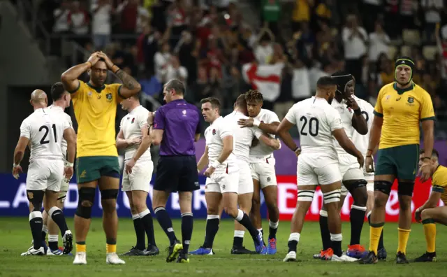 England celebrate while Australia players look dejected after the match