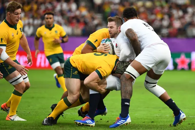 England's full back Elliot Daly (2nd R) is tackled during the Japan 2019 Rugby World Cup quarter-final match between England and Australia at the Oita Stadium in Oita