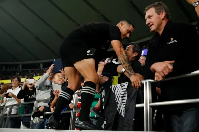 Aaron Smith collects an All Blacks flag from the crowd