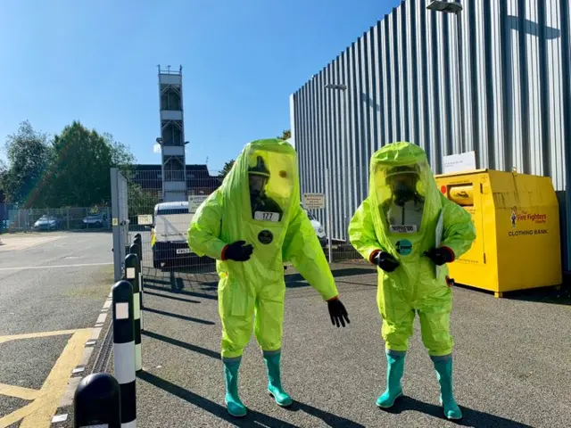 Firefighters in chemical suits