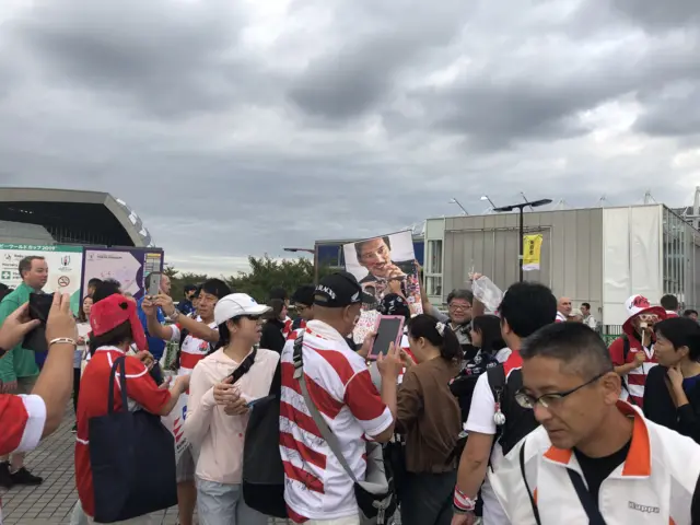 Fans pay their respects to a picture of Hirao