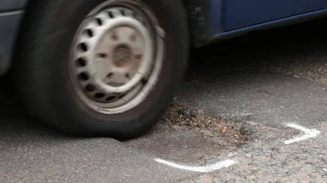 A van drives over potholes