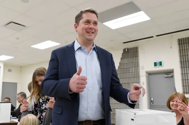 Conservative leader Andrew Scheer gives a thumbs-up as he votes in the federal election in Regina Saskatchewan on October 21, 2019. - Canadians began voting in a general election, with surveys predicting that Prime Minister Justin Trudeau's Liberal Party could return with a weakened minority government or lose his grip on power entirely.