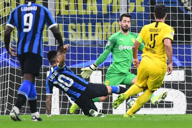 Argentinian forward Lautaro Martinez (2ndL) shoots to open the scoring during the UEFA Champions League Group F football match Inter Milan vs Borussia Dortmund