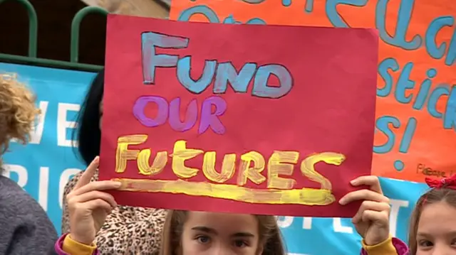 Pupil holding a protest sign