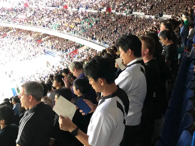 Japanese fans singing anthems of lyric sheets