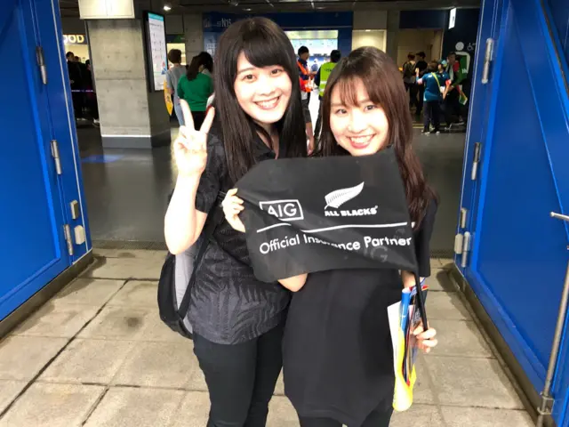 Two Japanese fans in All Blacks shirts