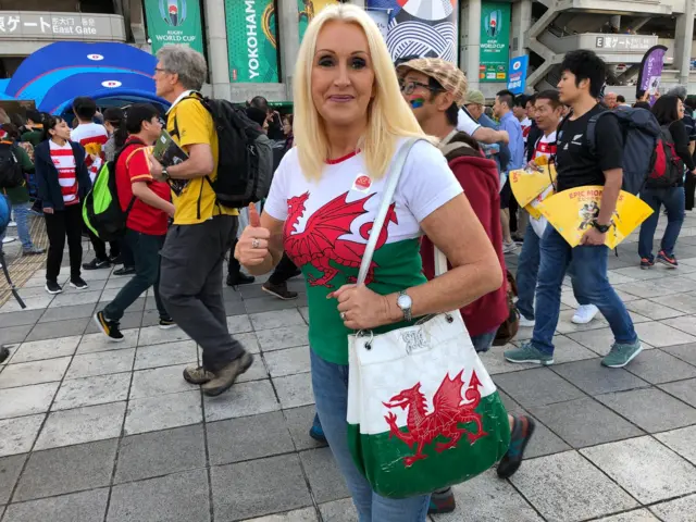 A woman with a Wales t-shirt and handbag