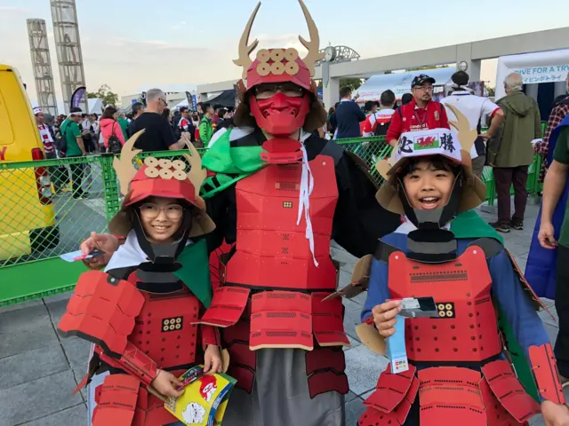 Japanese fans dressed as samurai with Welsh flags