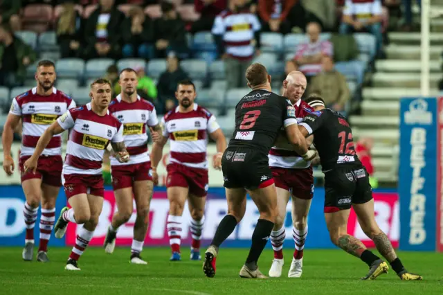 Wigan's Liam Farrell is tackled by Salford's Lee Mossop and George Griffin.