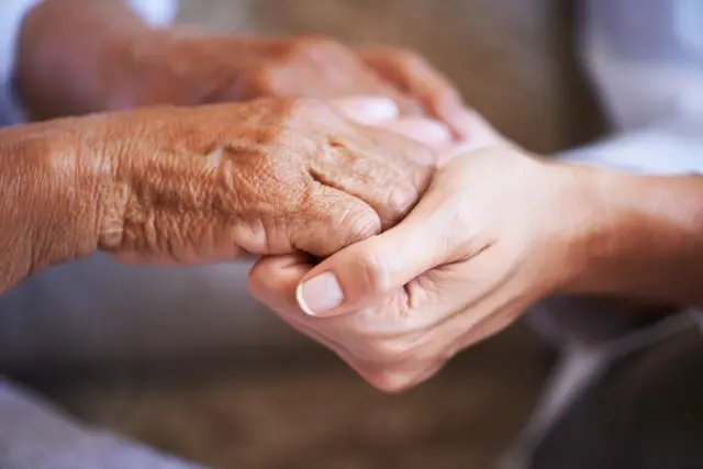 Care home residents holding hands