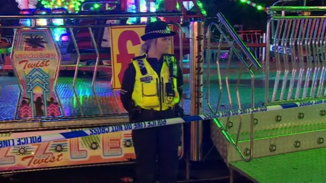 A police officer stands in front of a ride