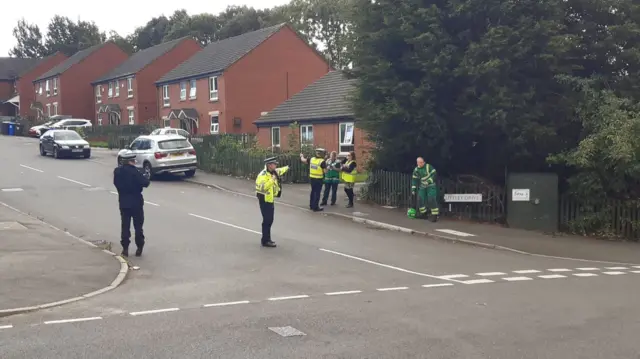 Police leading people away from their homes