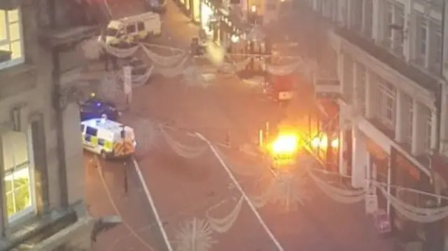 Flames on street with police