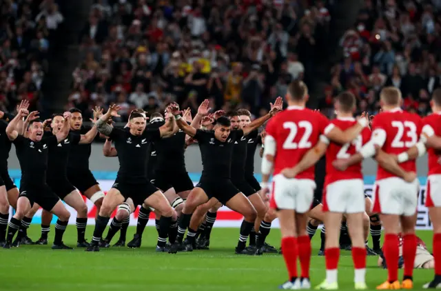 Wales link arms during the New Zealand haka