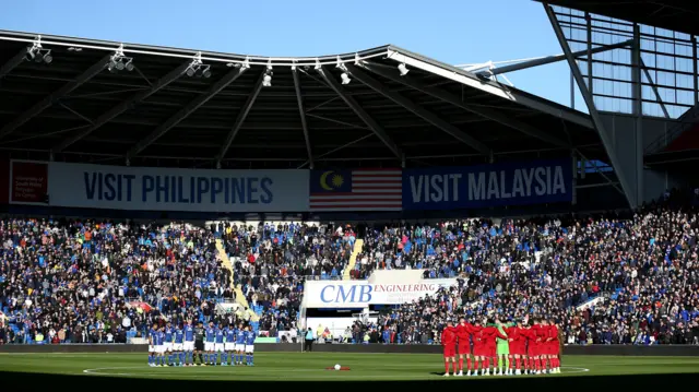 Players and fans observe a minute's silence