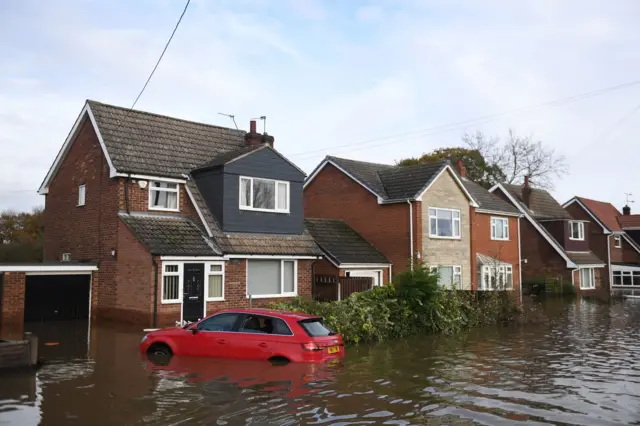 Homes surrounded by water in Fishlake, Doncaster as parts of England endured a month"s worth of rain in 24 hours, with scores of people rescued or forced to evacuate their homes.