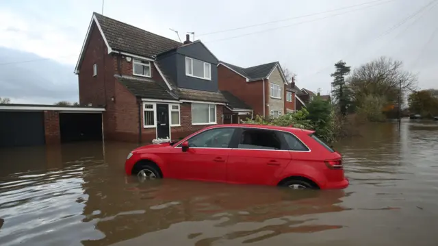 A car outside a flooded house