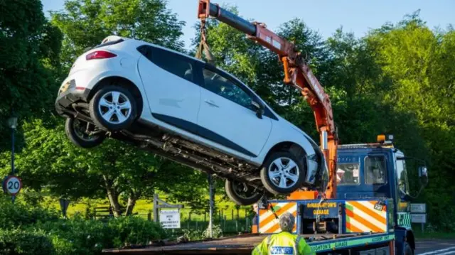 Car being lifted off road