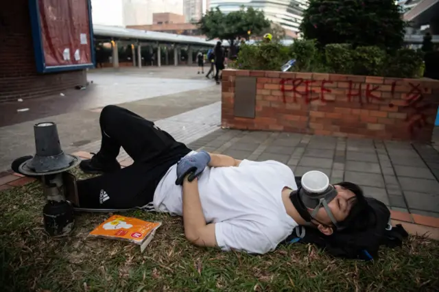 An anti-government protester sleeps after clashes with police at Hong Kong Polytechnic University on November 18, 2019 in Hong Kong, China