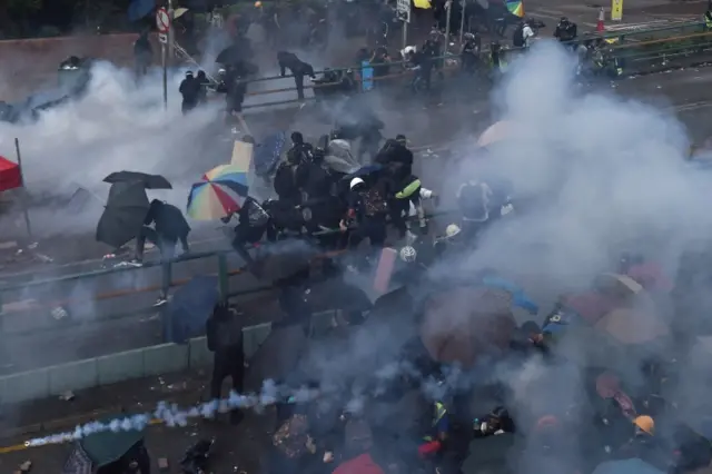 Protesters attempt to find safe passage out of the Hong Kong Polytechnic University campus as riot police fire tear gas and move in