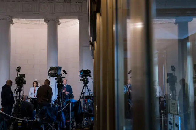 TV journalists outside the hearing room