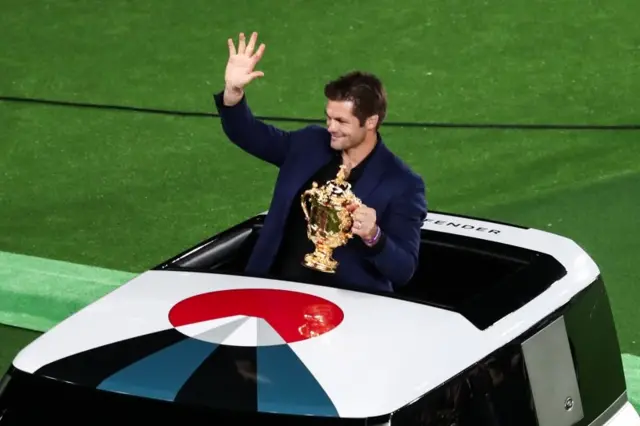 Former New Zealand player Richie McCaw holds the Webb Ellis Cup