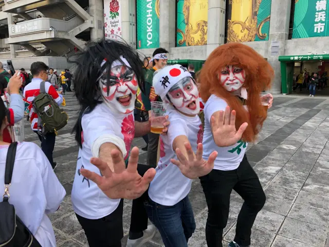 Japanese fans with face paint and wigs