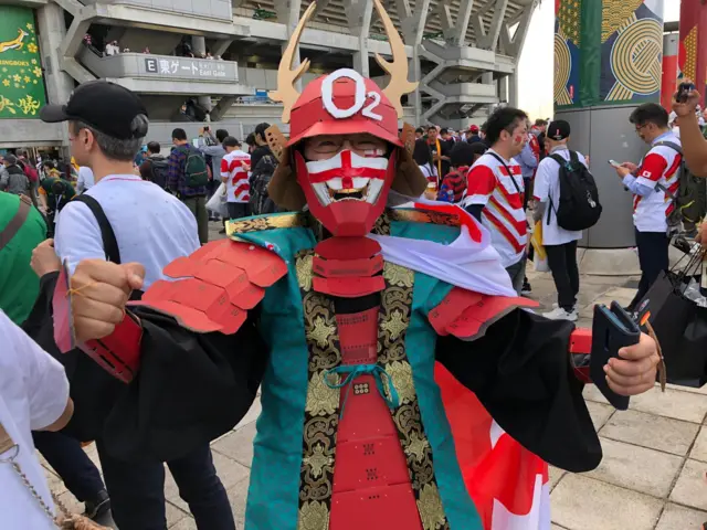 A Japanese man dressed as a samurai with England flags