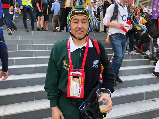 Japanese fan with half and half South Africa and New Zealand shirt and Springbok scrum cap