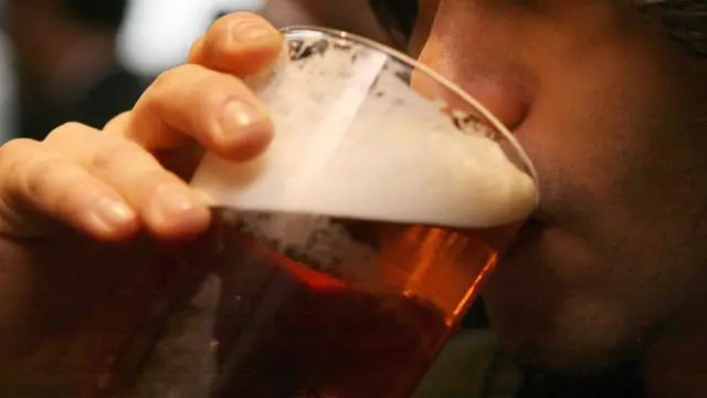 A man drinking a pint of beer