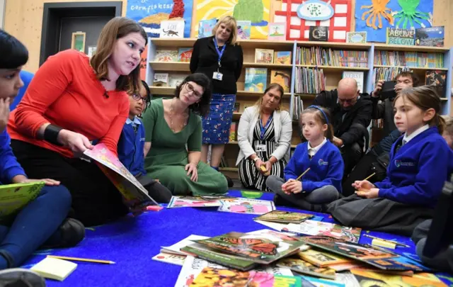 Swinson with schoolchildren