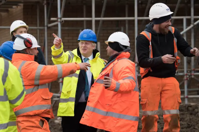 Prime Minister Boris Johnson (centre) during a visit to David Wilson Homes in Bedford