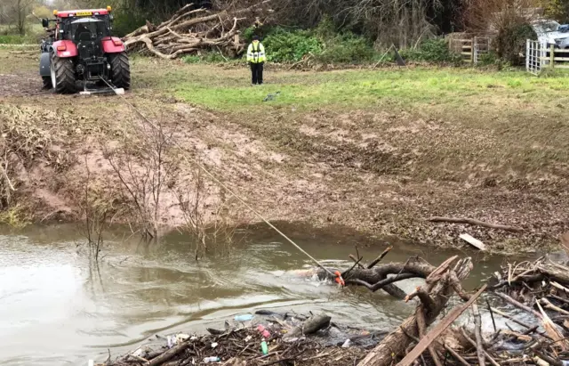 Tractor clearing river